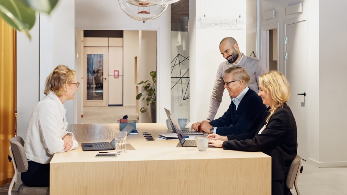 Four colleagues chatting at the office while working