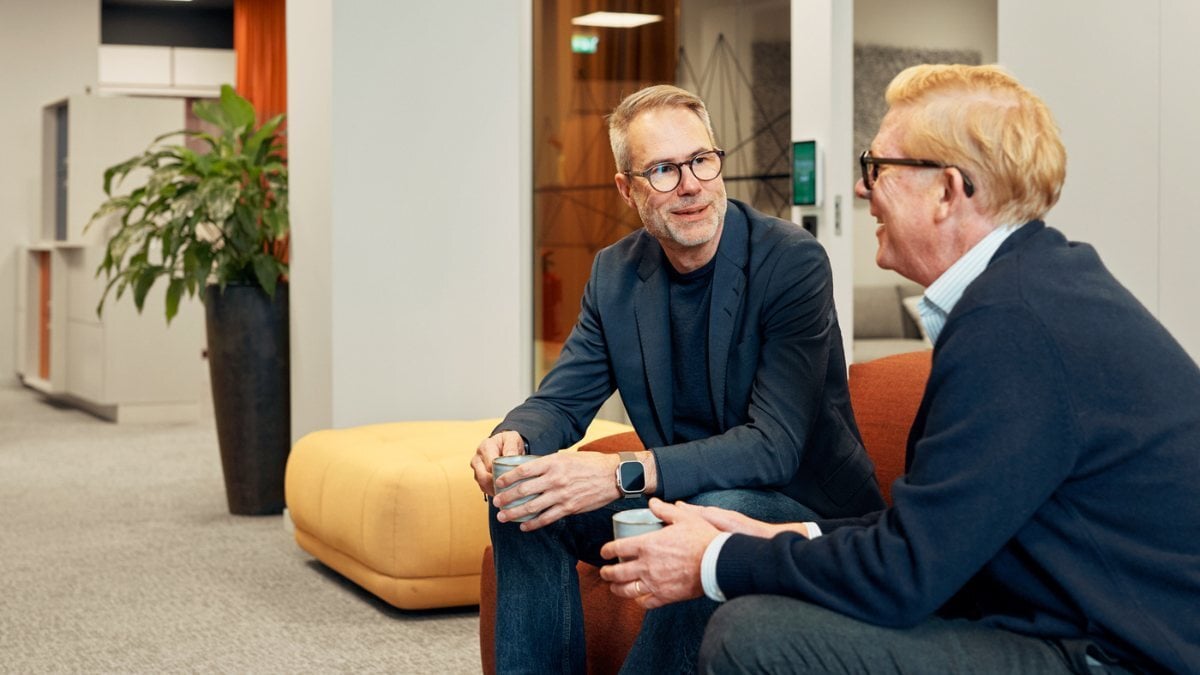 Two colleagues chatting while drinking coffee