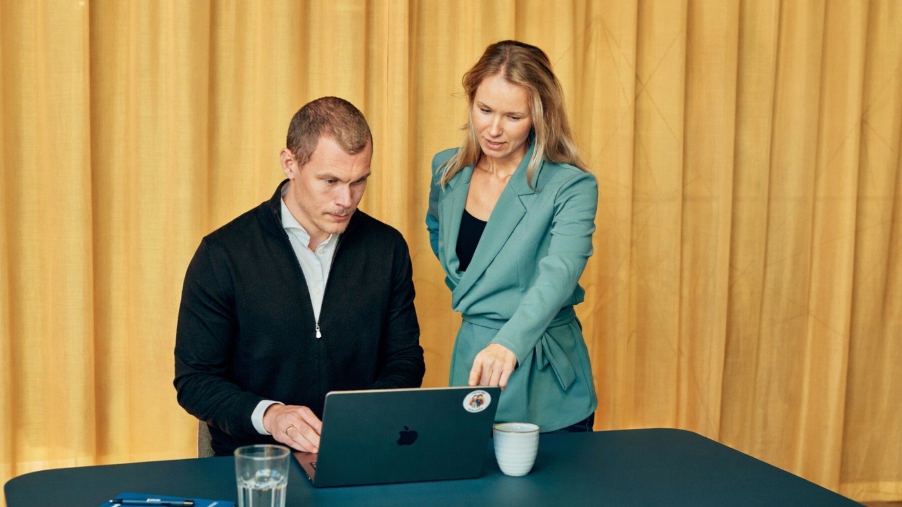Two colleagues looking at something in the laptop